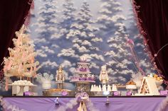 an elaborately decorated stage set up for a birthday party with purple and white decorations