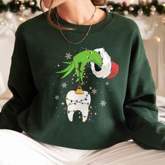 a woman wearing a green christmas sweater with an elf on it