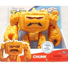 an orange toy with big eyes and fangs on it's face in a box