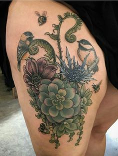 a woman's thigh with flowers and birds on it