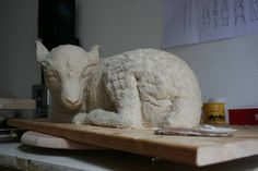 a sculpture of a sheep sitting on top of a table