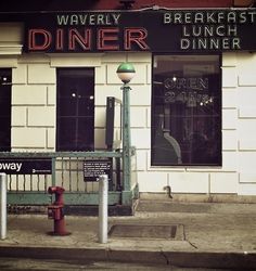 the front of a restaurant with a red fire hydrant on the sidewalk in front of it