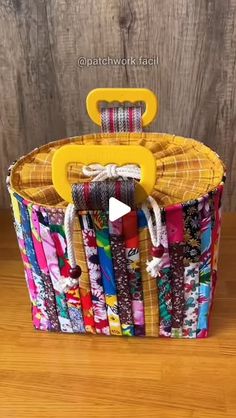 a basket that has some fabric in it and a yellow handle on the top of it