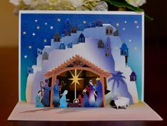 a nativity scene with flowers in the background