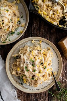 two plates of pasta with corn and parmesan cheese