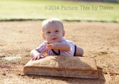 a baby laying on the ground with his hand out to catch a baseball in it's mitt