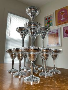 a group of wine glasses sitting on top of a wooden table next to a window