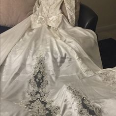 a white wedding dress sitting on top of a chair