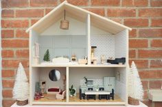 a doll house with furniture and accessories on display in front of a brick wall,