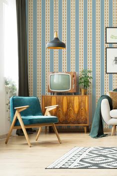 a living room with blue and white striped wallpaper, two chairs, a television set, and a rug on the floor