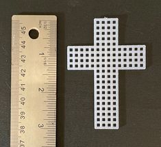 a ruler next to a cross on a table