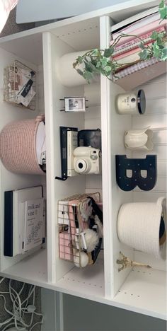 an organized shelf with toilet paper, books and other items on it's sides