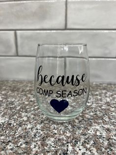 a wine glass that says because comp season with a blue heart on it sitting on a counter