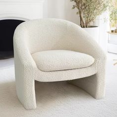 a white chair sitting on top of a carpeted floor next to a fire place