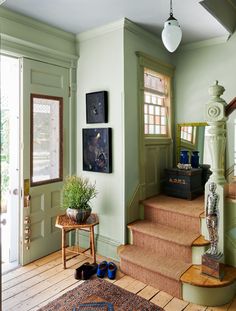 there is a staircase leading up to the second floor in this house with green walls and wood floors