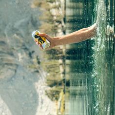 a hand holding a can of beer in the water