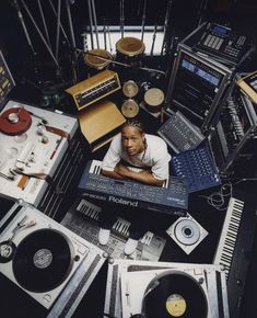 a man is surrounded by various electronic equipment