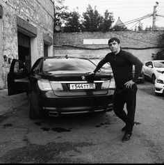 a man standing next to a parked car