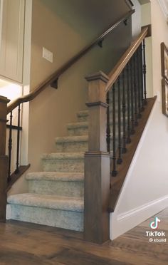 the stairs are made of wood and have metal handrails on them, along with carpeted flooring