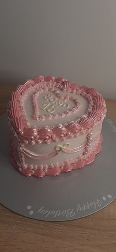 a heart - shaped cake with pink frosting is on a platter that says, i love you