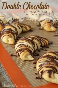 chocolate covered croissants sitting on top of a cookie sheet