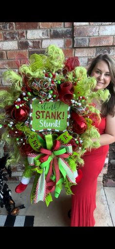 a woman in a red dress is holding a wreath with the words santa's sleigh on it