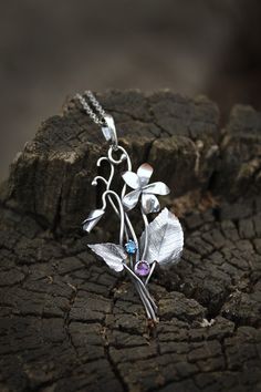 ITEM DESCRIPTION: The size H 5 cm x W 3 cm (2 x 1 1/3 inch). Weight - 3 g. You can buy it with a silver chain or without it. This spring flower is so delicate. So I was inspired by nature and made a wild violet flower of sterling silver, amethyst, and blue zircon. This is a very detailed handmade necklace. This floral jewelry will be a great addition to your jewelry collection or gift for someone whose you love. This handmade necklace will come to you in a gift box - ready for gifting. The parce Silver Nature-inspired Necklace With Flower Charm, Silver Necklace With Nature-inspired Flower Charm, Sterling Silver Birth Flower Pendant Jewelry, Sterling Silver Birth Flower Pendant, Nature-inspired Flower Charm Pendant Necklace, Nature-inspired Silver Flower Necklace With Charm, Nature-inspired Sterling Silver Flower Jewelry, Nature-inspired Flower Shaped Sterling Silver Jewelry, Sterling Silver Flower Pendant Jewelry