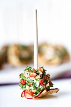 a small appetizer on a stick with toppings