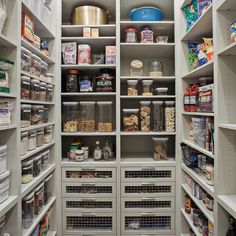 an organized pantry with white shelving and lots of food on the shelves in it