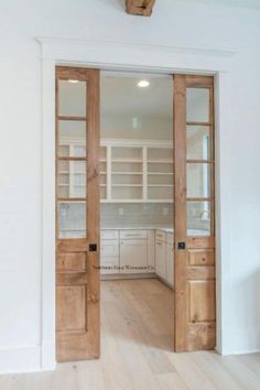 an empty kitchen with wooden doors and white walls