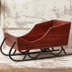 a small wooden sleigh sitting on top of a white table next to a wall