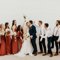 a group of people standing next to each other in front of a white brick wall