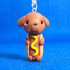 a small toy dog with a yellow letter s on it's chest is sitting in front of a blue background