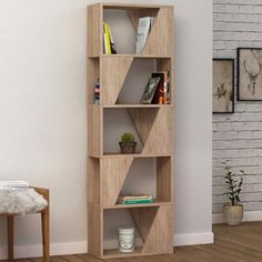 a wooden shelf with books on it next to a white brick wall in a living room