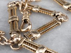 "This antique chain was originally used to hold a pocket watch, but it also makes a gorgeous choker necklace! The links are superbly crafted, with wire spirals and sleekly polished bars of 14 karat gold. This is a weighty, impressive piece and could also be worn double wrapped as a bracelet! Metal: 14K Yellow Gold Width of Chain: 7 mm Length of Chain: 13.5 Inches Marks: \"A\" Stamped on the clasp To view a video of this piece check out the link below: https://vimeo.com/579554515 SKU #: 16ZD2LNM Bracelet Metal, Pocket Watch Chain, Cameo Ring, Hand Ring, Watch Chain, Suit Accessories, Blue Zircon, London Blue Topaz, Metal Bracelets