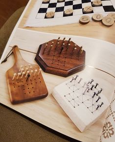 three wooden objects are sitting on a table next to some buttons and checkered cloth