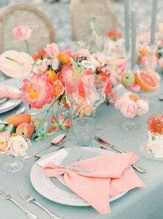 the table is set with pink and orange flowers