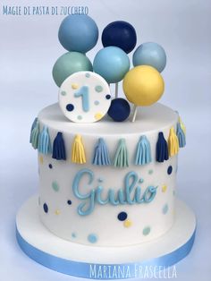 a white cake with blue and yellow decorations