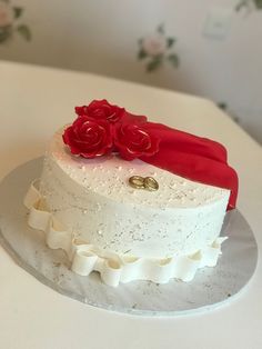 a white cake with red flowers on top