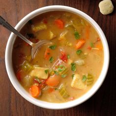 a bowl of soup with carrots, celery and tofu in it