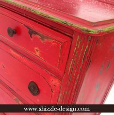 an old red dresser with green paint on it