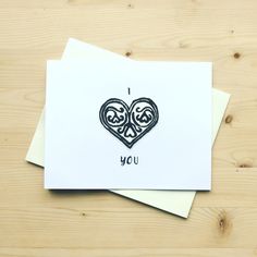 two greeting cards with the words i love you printed on them, sitting next to each other