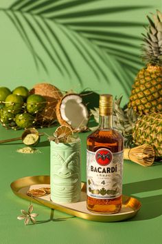 a bottle of bacardi sitting on top of a tray next to a pineapple