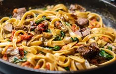 a pan filled with pasta and meat on top of a table