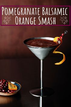 an orange mash is garnished with pomegranate in a martini glass