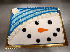 a frosted cake decorated with a snowman's face