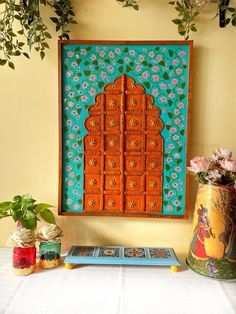 a table topped with vases filled with flowers next to a painting on the wall