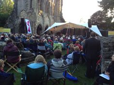 an outdoor concert with people sitting in lawn chairs