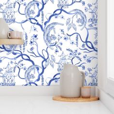 a blue and white wallpaper in a kitchen with a vase on the counter next to it