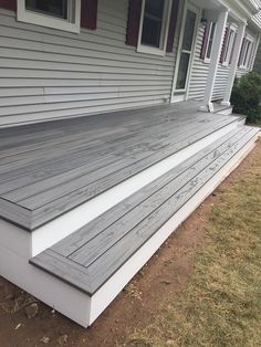 a house with white siding and gray wooden steps